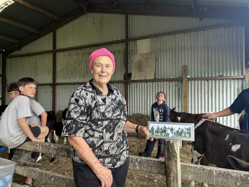 Photo depicts Janet Macky holding a framed picture.