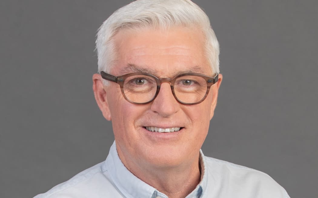 Mark Leishman smiling in front of grey background