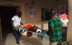 Paramedics stretcher a victim of a blast at the hospital in Maiduguri on June 17, 2018.