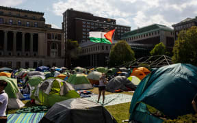 A demonstrator at the encampment established in support of Palestinians in Gaza waves the Palestinian flag at Columbia University on April 29, 2024 in New York City.