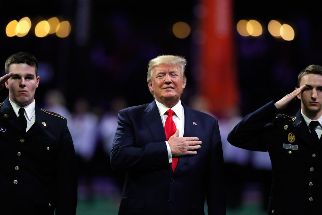 US President Donald Trump on field during the national anthem prior to the CFP National Championship presented by AT&T between the Georgia Bulldogs and the Alabama Crimson Tide at Mercedes-Benz Stadium on January 8, 2018 in Atlanta, Georgia.