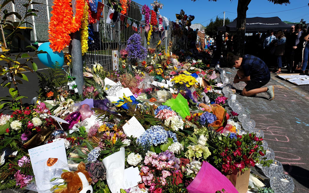 A child lights a candle outside Al Huda Mosque in Dunedin.