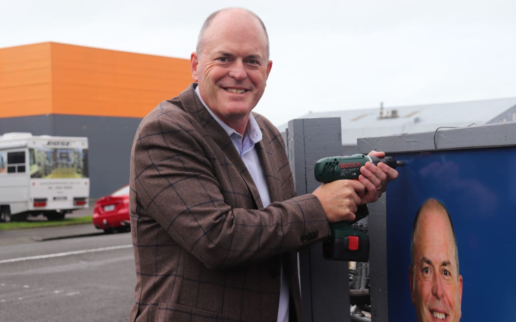 Todd Muller places the final screw in the new billboard in Napier