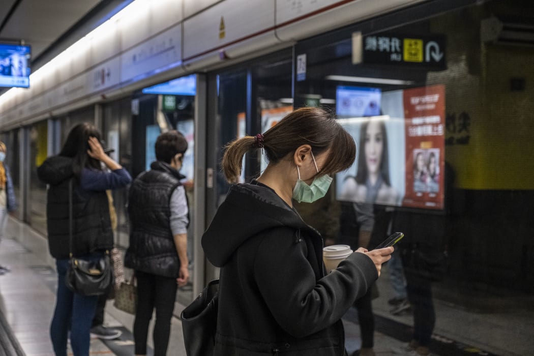 A woman wears a mask as she waits for an MTR Train on a platform in Tsim Sha Tusi on January 22, 2019 in Hong Kong, China.