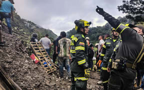 Handout picture released by Colombia's National Police press office showing rescuers working in the site of a landslide in the sector El Ruso, Pueblo Rico municipality, in northwestern Bogota, Colombia, on December 4, 2022.