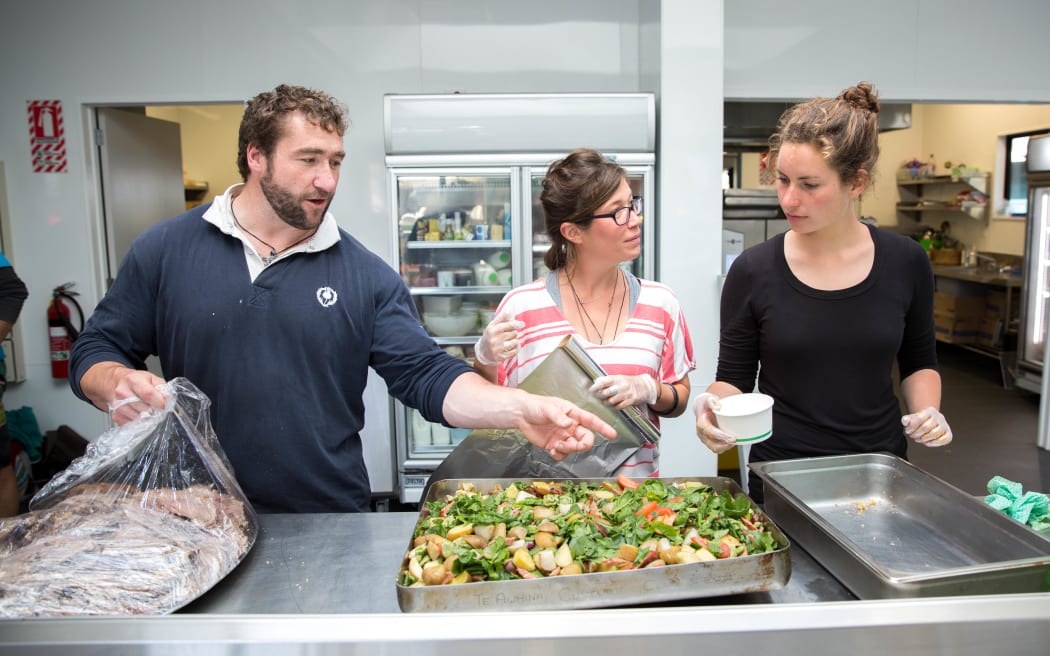 David Burt (left) and two other volunteers work in the marae kitchen to prepare tonight's final dinner for the community.