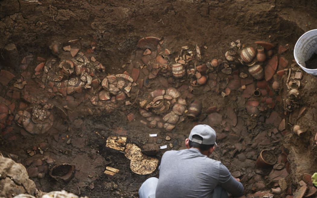 This handout picture released by Panama’s Ministry of Culture shows an archaeologist working inside a pre-Hispanic tomb approximately 1,200 years old, discovered at the El Cano Archaeological Park in Cocle, Panama, on February 20, 2026. The tomb contained the remains of a high-ranking lord of the Cocle culture, along with abundant gold and ceramic grave goods. (Photo by Handout / Panama / AFP) / RESTRICTED TO EDITORIAL USE - MANDATORY CREDIT "AFP PHOTO /  PANAMA’S MINISTRY OF CULTURE" - HANDOUT - NO MARKETING NO ADVERTISING CAMPAIGNS - DISTRIBUTED AS A SERVICE TO CLIENTS