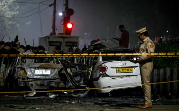 A police personnel inspects charred vehicles at the blast site after an explosion near the Red Fort in the old quarters of Delhi on 10 November, 2025.