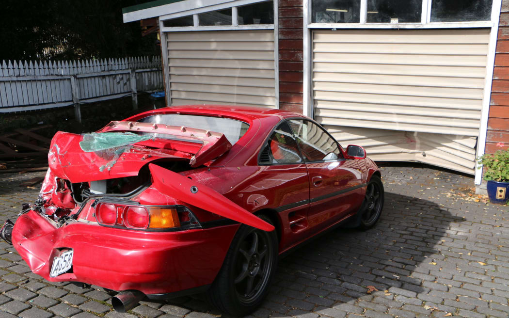 The car and garage damaged during the carjacker's getaway.