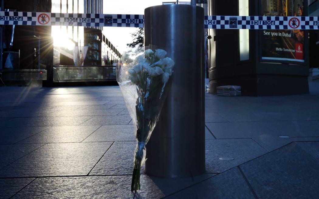 A bunch of flowers rests beside a bollard near the Lindt chocolate cafe in Martin Place following the siege.