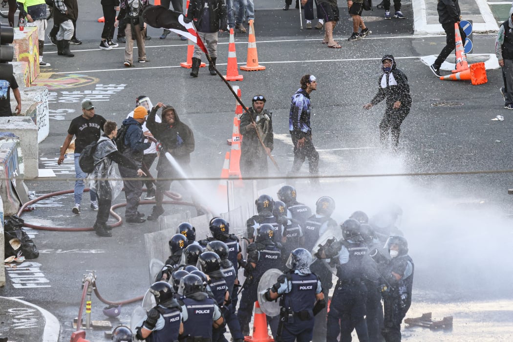 Protesters gain control of a fire hose and aim that at police as well