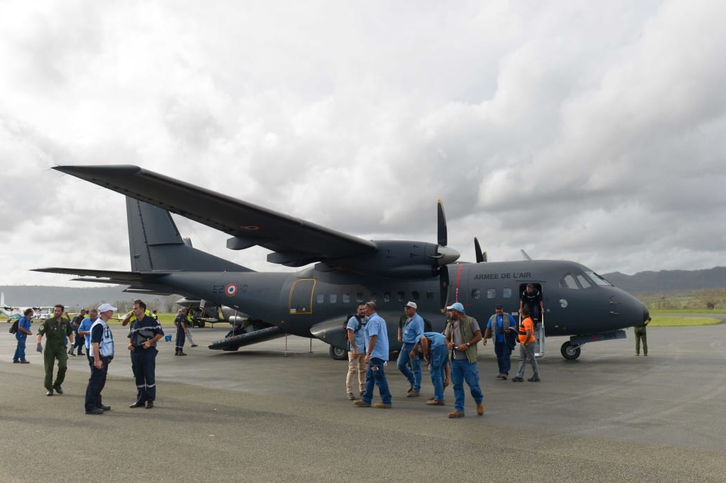 Rescuers standing by a French Army Casa logistics and transport plane, carrying relief and assistance after cyclone Pam.