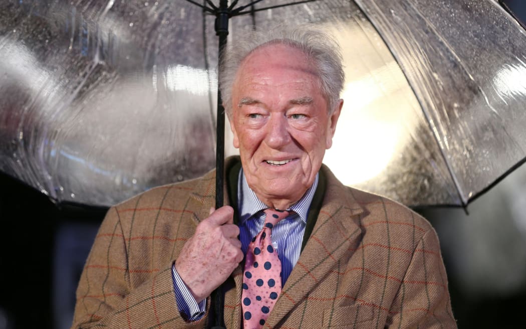 British actor Michael Gambon shelters from the rain as he arrives for the world premiere of the film Dad’s Army in London on 26 January, 2016.