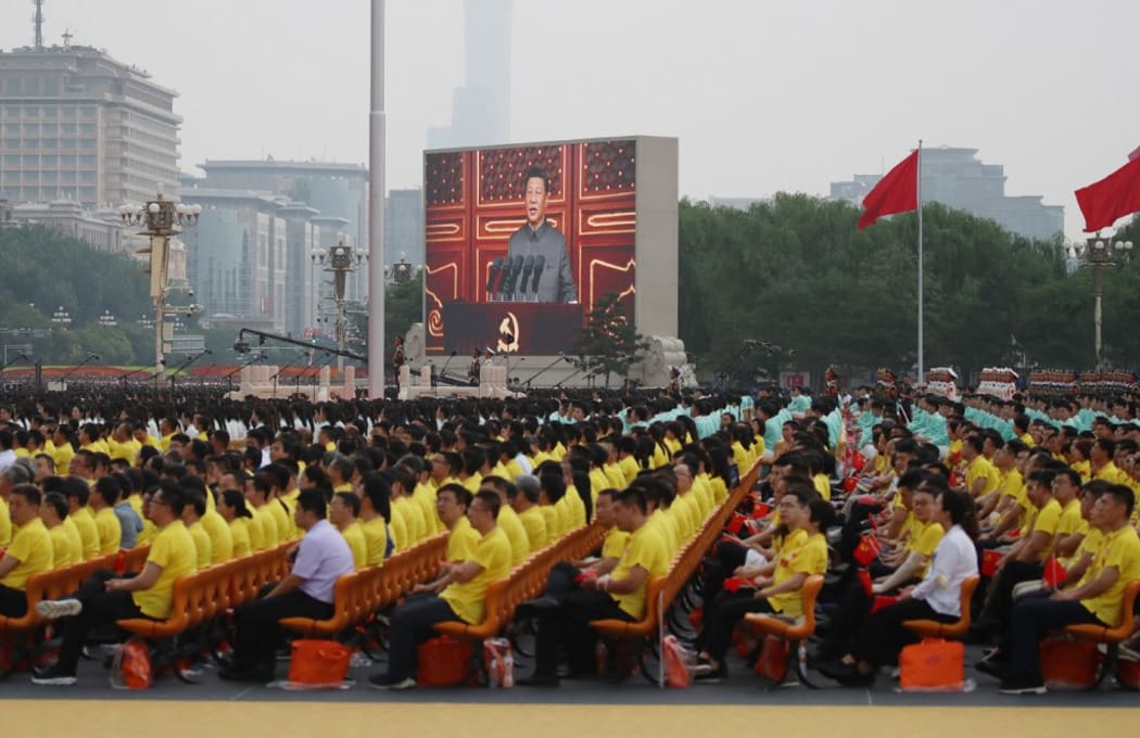 A large screen shows President of the People's Republic of China (PRC) Xi Jinping speaking during a ceremony to commemorate the 100th anniversary of the founding of the Chinese Communist Party at Tiananmen Square in Beijing on July 1, 2021.
