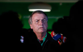(FILES) Brazilian former President, Jair Bolsonaro, speaks to the press at the Juscelino Kubitschek International Airport in Brasilia on June 30, 2023. Brazil's former president Jair Bolsonaro will surrender his passport to authorities, his lawyer said on February 8, 2024, as police carried out a series of raids targeting suspects accused of a "coup" attempt. (Photo by Sergio Lima / AFP)