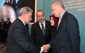 Turkish President Recep Tayyip Erdogan shakes hands with Foreign Minister Winston Peters during an Organization of Islamic Cooperation meeting.