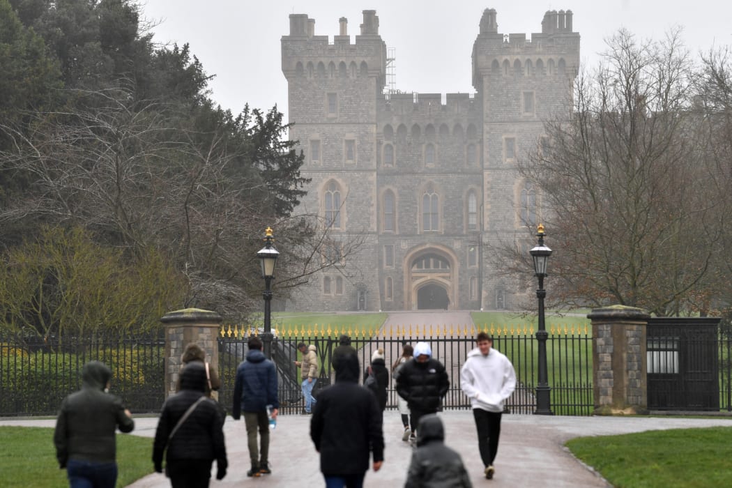 People walk up to the gates of Windsor Castle, the main residence of Britain's Queen Elizabeth II, on 20 February. The Queen tested positive for Covid-19 a fortnight after marking 70 years on the throne.