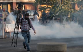 A member of the media runs through tear gas during a protest on May 28, 2020 in St. Paul, Minnesota.