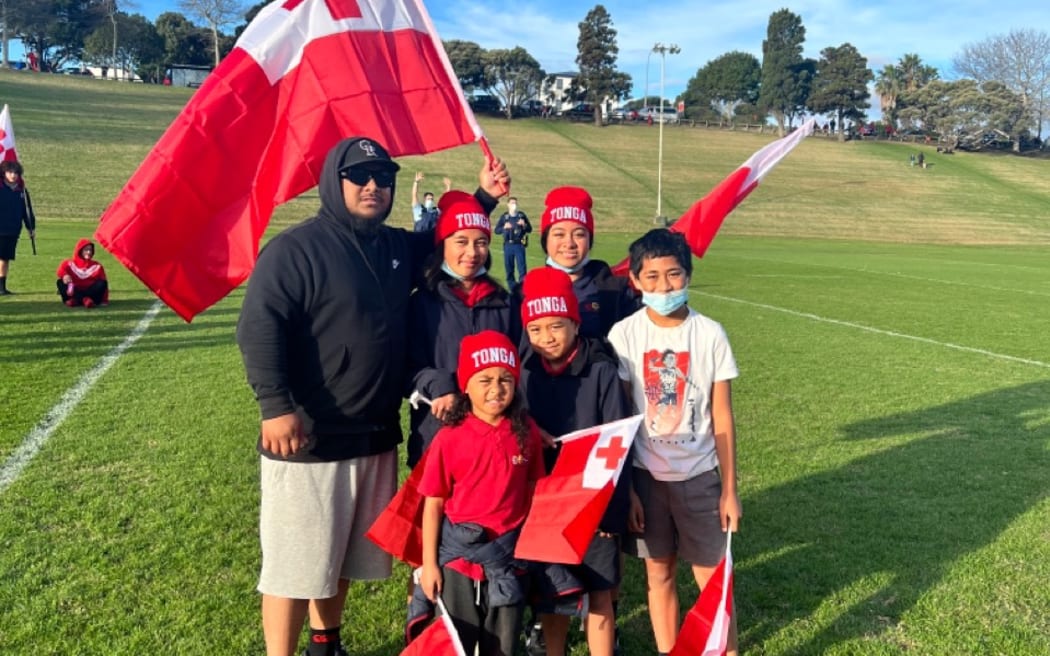A group of Mate Maa Tonga supporters proudly wave the Tongan flag.