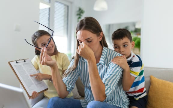 Exhausted and fed up mum and parent with children on her.