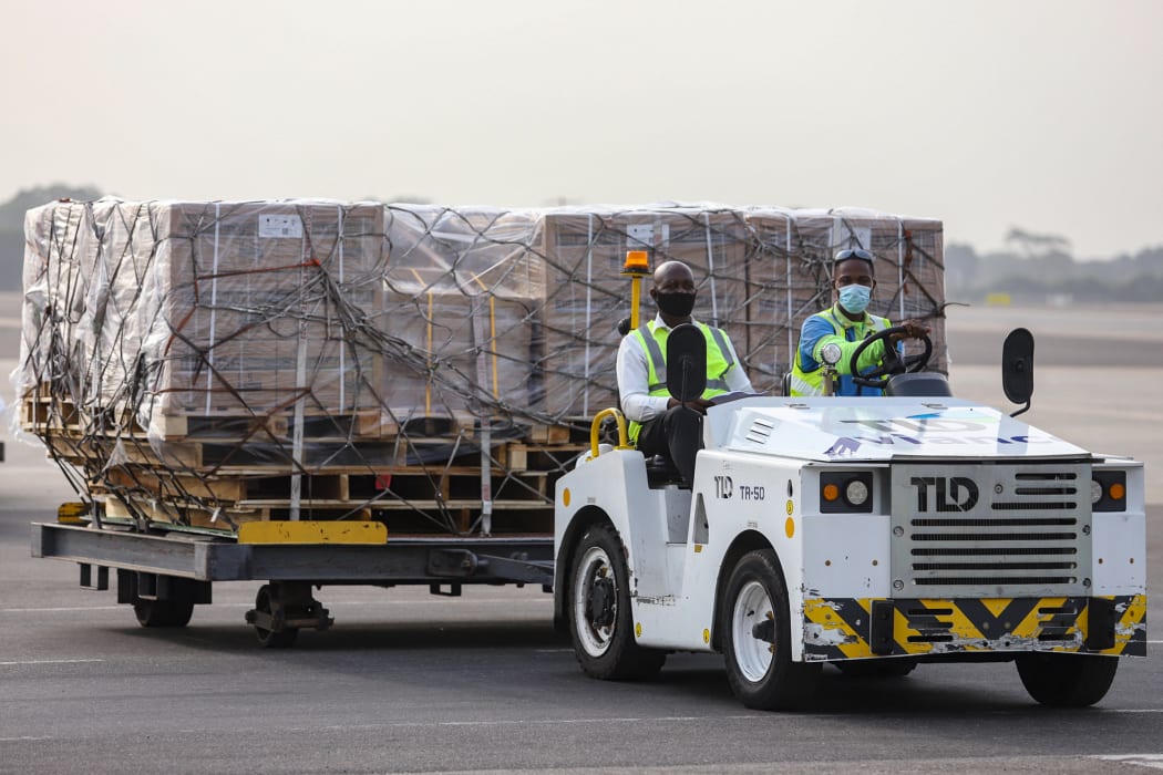 Airport workers transport part of a shipment of Covid-19 vaccines from the Covax programme, at the Kotoka International Airport in Accra, 24 February 2021.