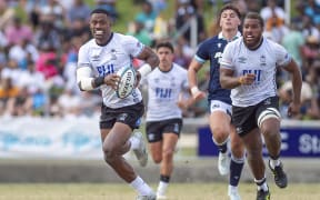 Fiji's Jiuta Wainiqolo (L) runs the ball towards the try line during the rugby Test match between Fiji and Scotland at HFC Bank Stadium in Suva on July 12, 2025. (Photo by Josua BUREDUA / AFP)