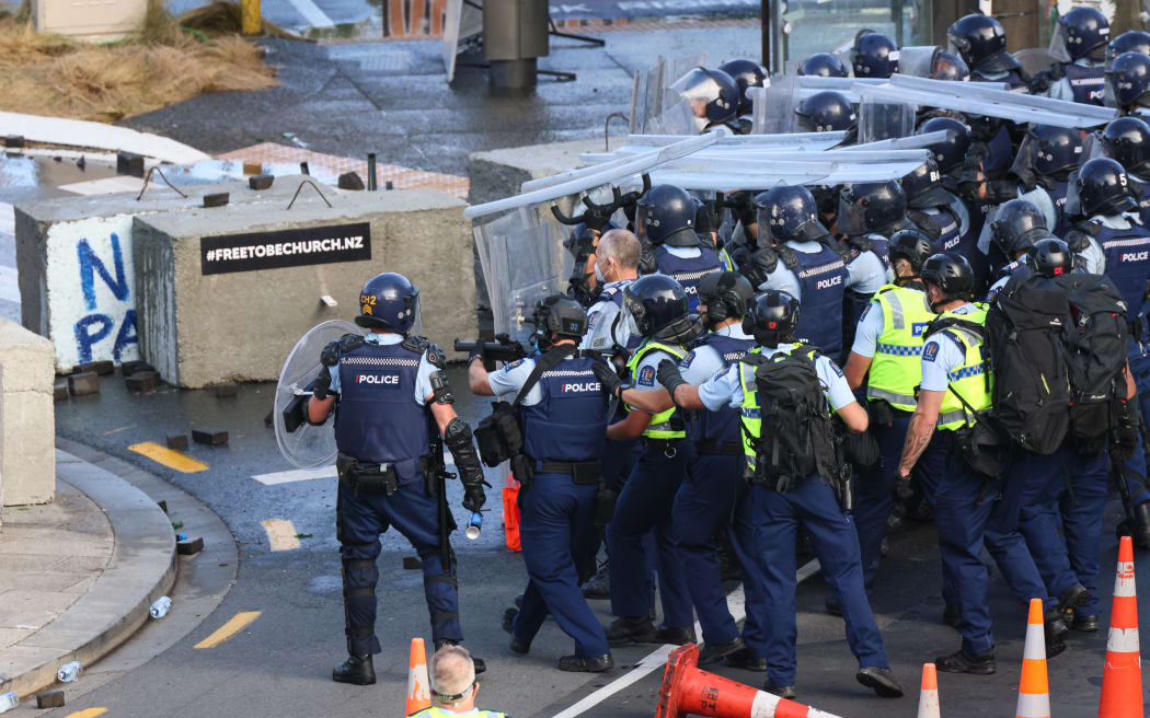 Police advance with the assistance of beanbag shotguns