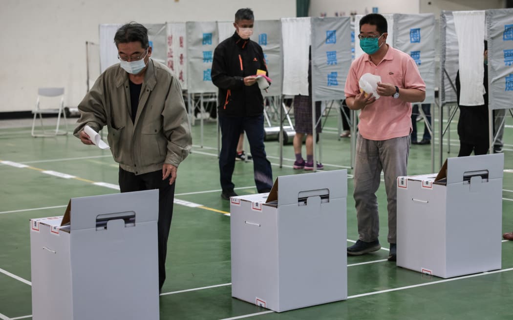 People cast their ballots to vote in the presidential election at a polling station in a high school in Tainan on January 13, 2024. (Photo by Yasuyoshi CHIBA / AFP)