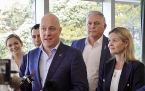 Prime Minister Christopher Luxon, left, speaks with reporters in Napier.