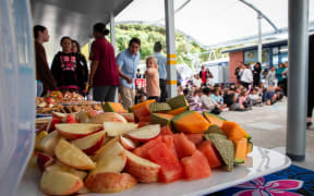 Children at Arakura School line up for free lunch