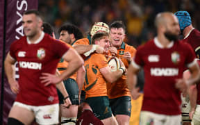 Tate McDermott of Australia celebrates with teammates after scoring a try against the British and Irish Lions, 2025.