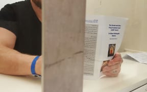 A drug court applicant in the holding cells looks over a leaflet about the court before his appearance