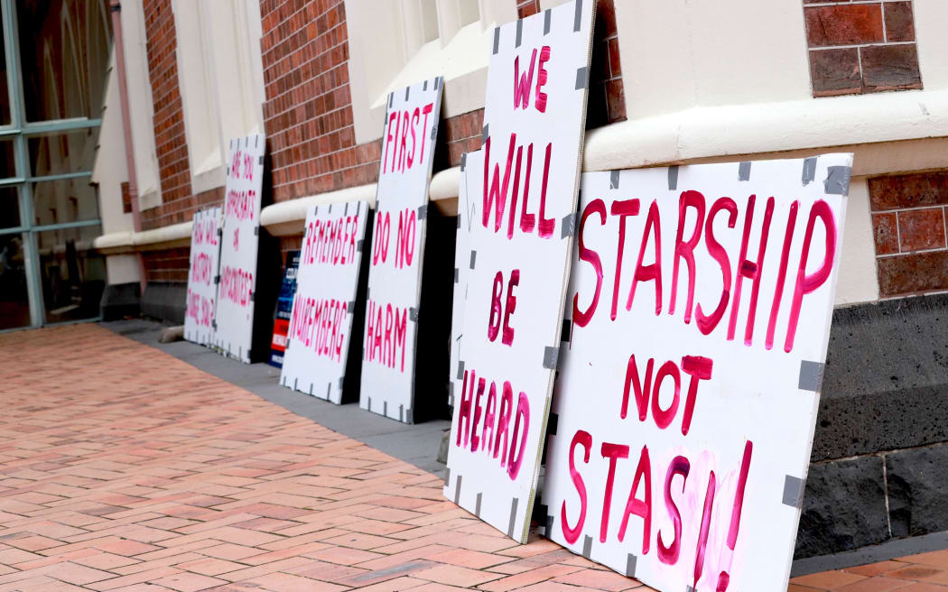 Signs outside the Court in Auckland on 30 November 2022 during a hearing on parents who wanted their baby to have blood transfusions only from someone who had not been vaccinated against Covid-19.