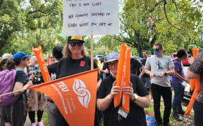 More than 100 University of Auckland staff and supporters rally for workers' rights on Princes Street on 1 March, 2023.