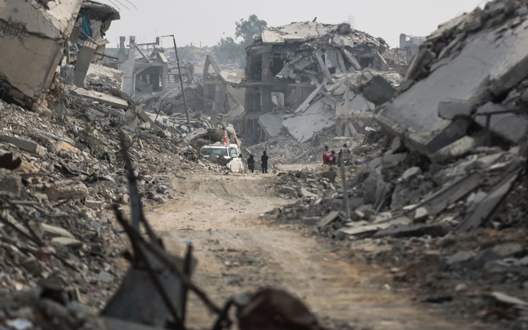 Hamas militants and members of the International Committee of the Red Cross (ICRC) search for the bodies of Israeli hostages in the rubble in Gaza City on November 3, 2025.