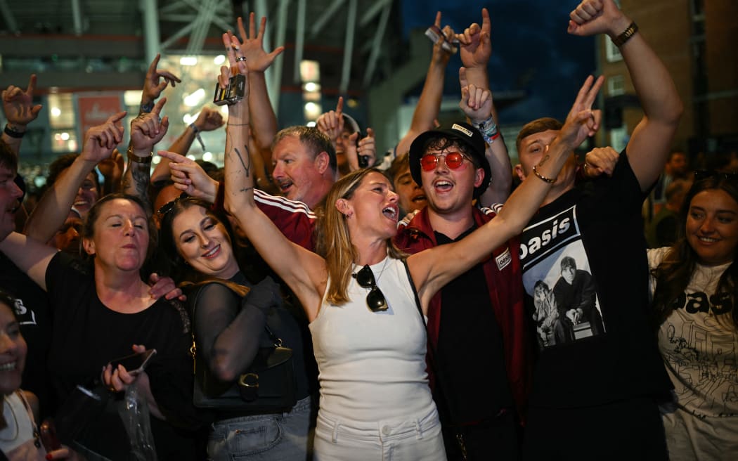 Fans of British rock band Oasis react outside the Principality Stadium in Cardiff on July 4, 2025, after attending the opening concert of their highly anticipated reunion tour nearly 16 years after last performing together. Two consecutive nights of concerts at the Principality Stadium in the Welsh capital mark the start of a 41-date run of gigs spanning the world. (Photo by Oli SCARFF / AFP)