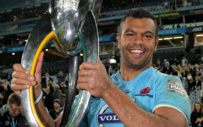 New South Wales' Kurtley Beale holds the 2014 Super Rugby trophy aloft.