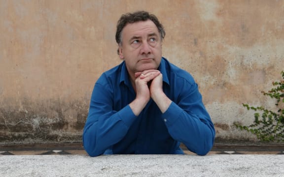 Musician Matthew Bannister looking pensive while leaning on a wall