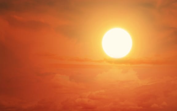 Glowing sun on the sky to illustrate heatwave or global warming.