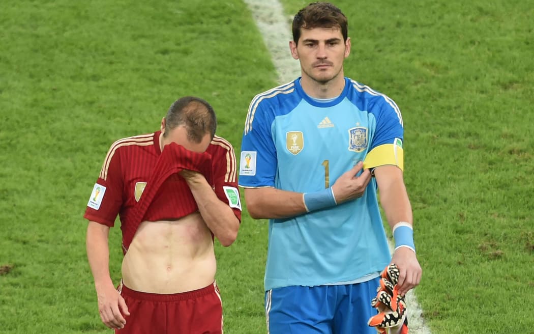 Spain's goalkeeper and captain Iker Casillas and midfielder Andres Iniesta walk off the pitch after losing their Group B match against Chile.