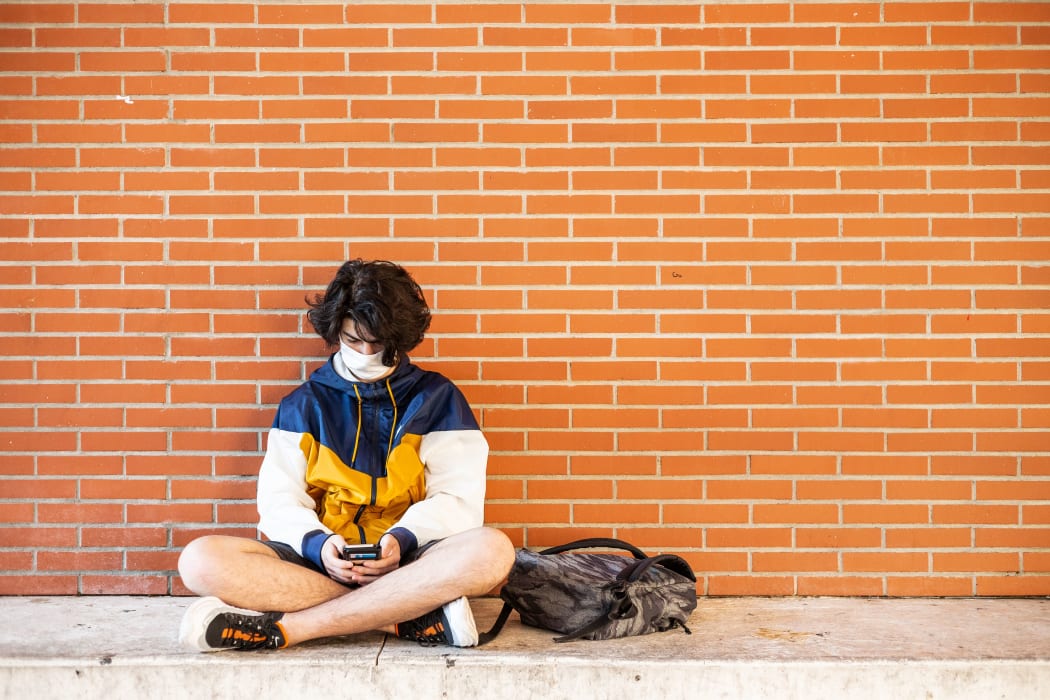 Perpignan, June 10, 2020, Classes resume at the Lycée Arago in Perpignan. History class with wearing of the mask for the teacher and the students. High school student waiting between two classes on his mobile phone and wearing the mask.