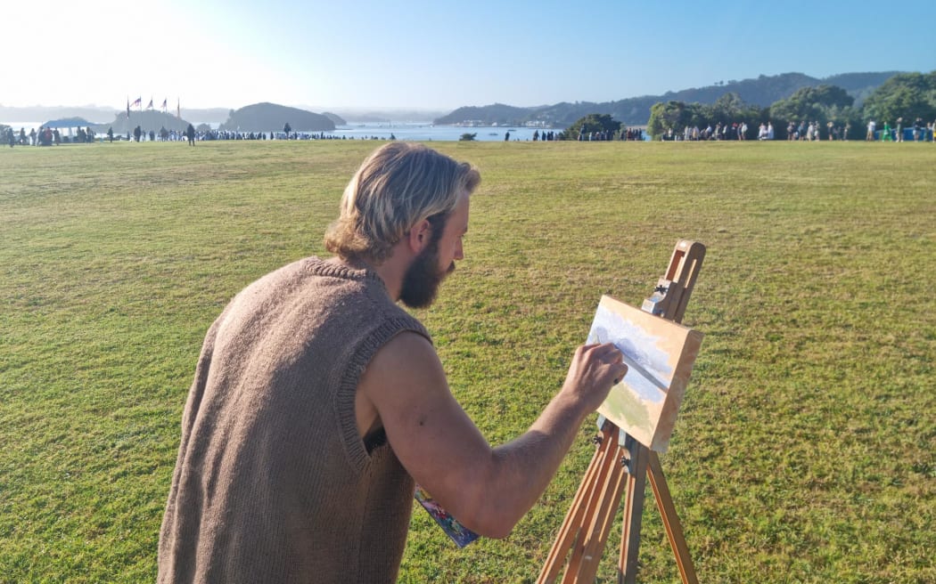 Chris Dews from Ōtaki painting on the Waitangi Treaty Grounds 5 February 2024. He says it's a very special time and wants to capture the landscape.