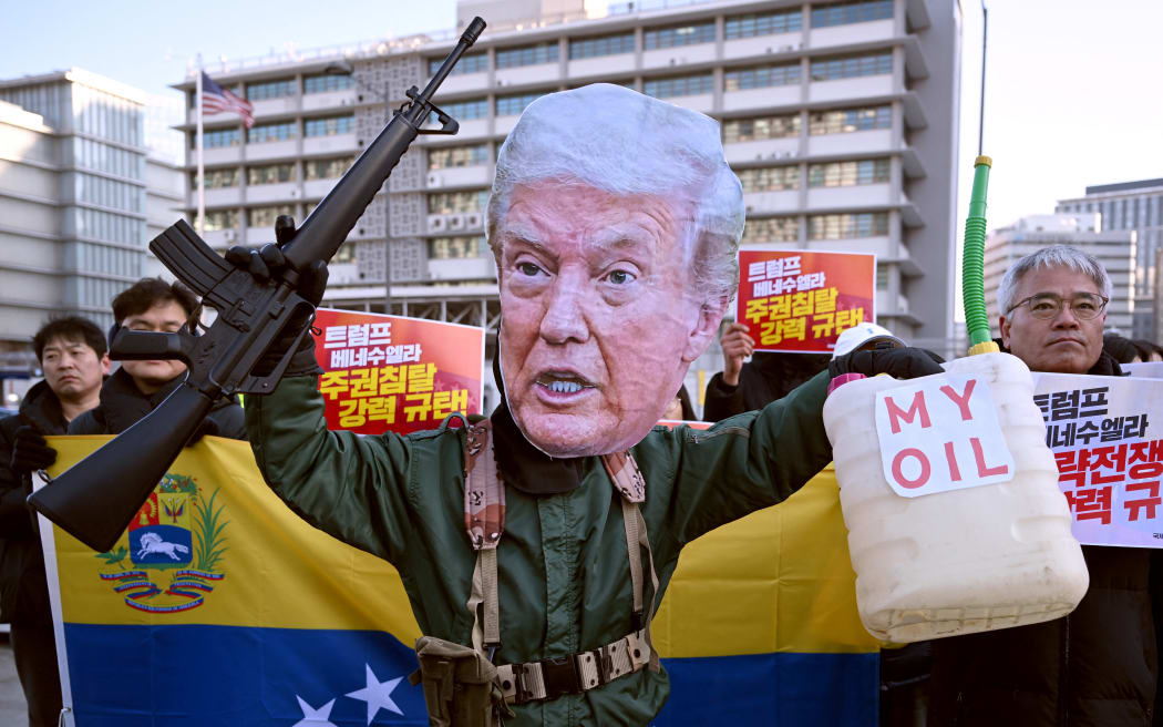 A protester wearing a mask of US President Donald Trump performs during a demonstration condemning the US attack on Venezuela and the seizure of Venezuelan leader Nicolas Maduro, in front of the US embassy in Seoul on January 5, 2026. (Photo by Jung Yeon-je / AFP)