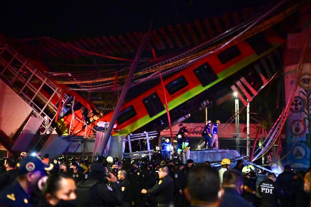 Rescue workers gather at the site of a metro train accident after an overpass for a metro partially collapsed in Mexico City.