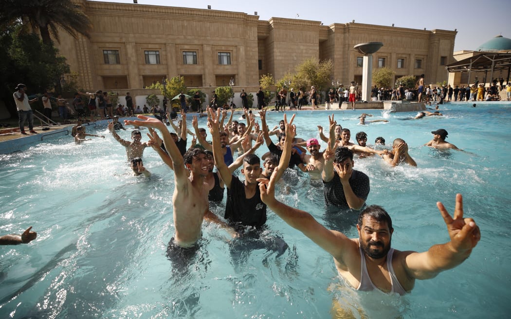 Supporters of Iraqi Shiite cleric Moqtada Sadr swim in the pool of the Government Headquarters in the capital Baghdad's Green Zone, on August 29, 2022.