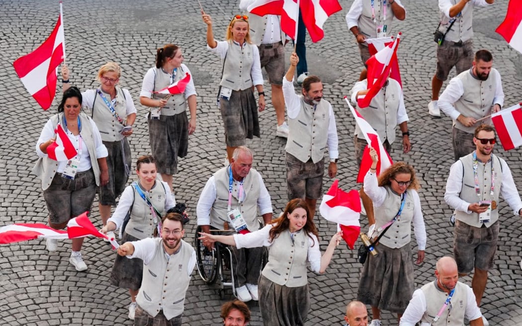 Austria's delegation arrive on the Champs-Elysees avenue during the Paris 2024 Paralympic Games Opening Ceremony in Paris on August 28, 2024. (Photo by Dimitar DILKOFF / AFP)