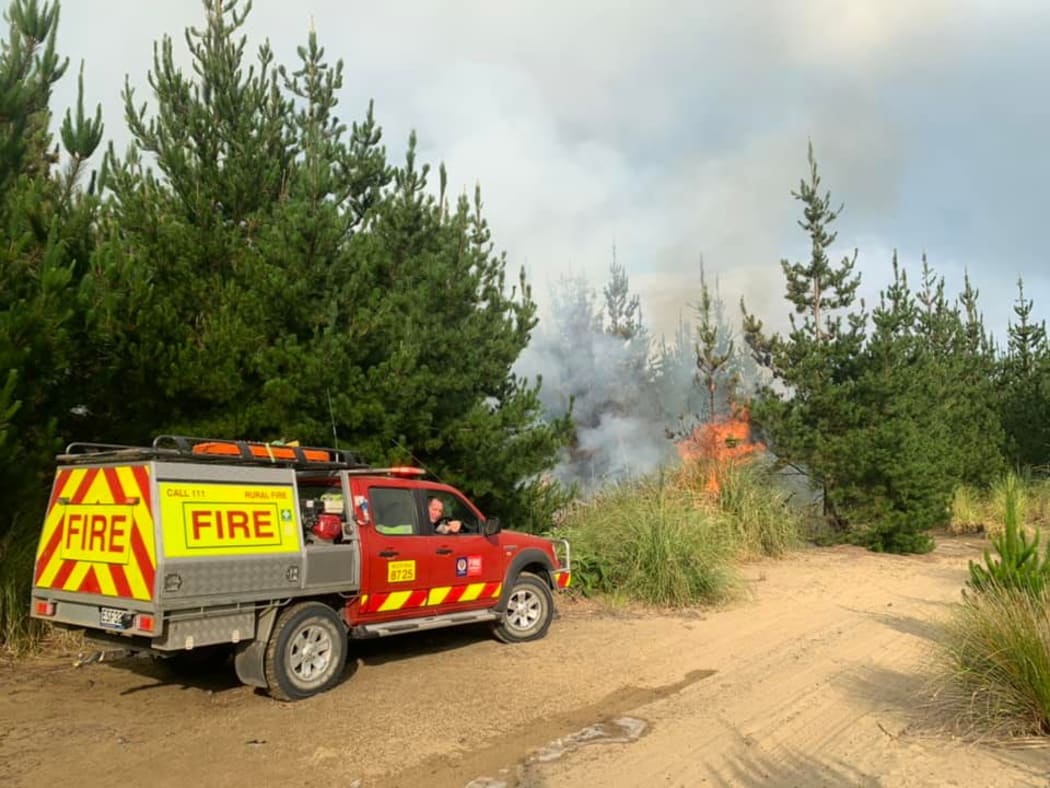 The Muriwai Volunteer Fire Brigade tackling a forest fire which started from a campfire at Muriwai Beach.