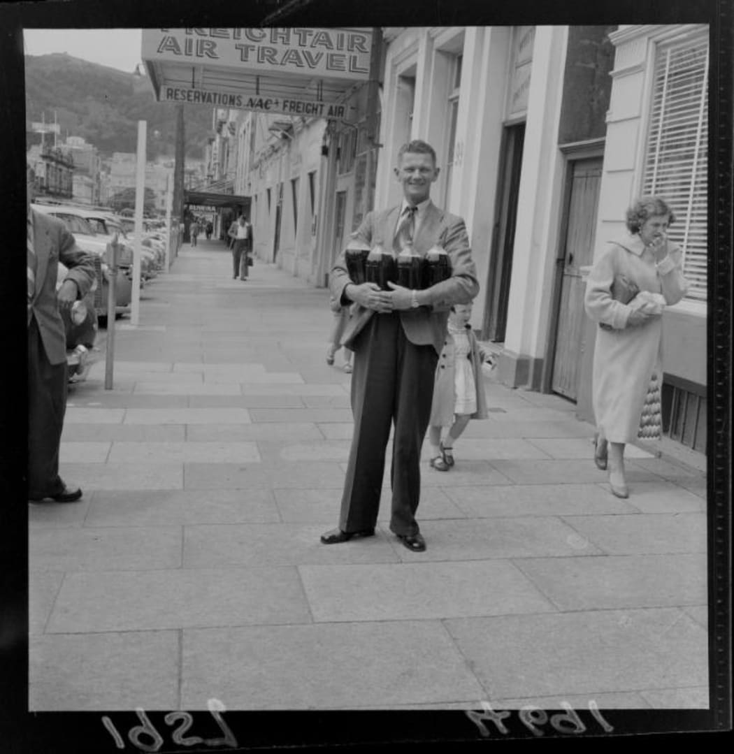 Man prepared for election day with four beer flagons. (1957) (Permission of the Alexander Turnbull Library, Wellington, New Zealand, must be obtained before any re-use of this image.)