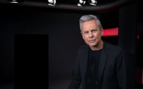 Guyon Espiner on a black background, looking at camera.