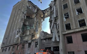 This handout picture released on March 30, 2022 by the State Emergency Service of Ukraine shows rescuers conducting search operations and dismantling the debris of a government building in Mykolaiv, which was hit by Russian rockets the previous day.
